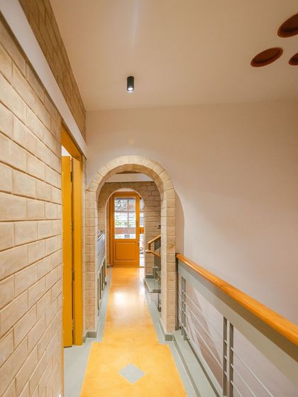 The corridor upstairs, with its Jaisalmer stone runner and stainless steel railings.