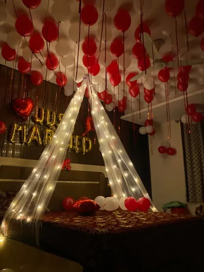A moody and romantic shot of a first night room setup, where the fairy lights on the canopy provide the main source of light.