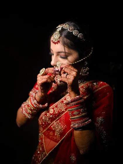 A candid moment of the bride adjusting her nath. This shot highlights the traditional elements of her look, all brought together by a flawless makeup application.
