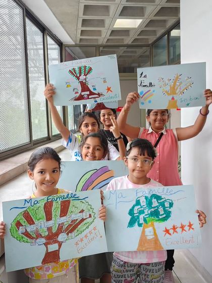 Our young learners proudly showing off their "Ma Famille" (My Family) tree drawings. It's a creative way to learn new vocabulary.