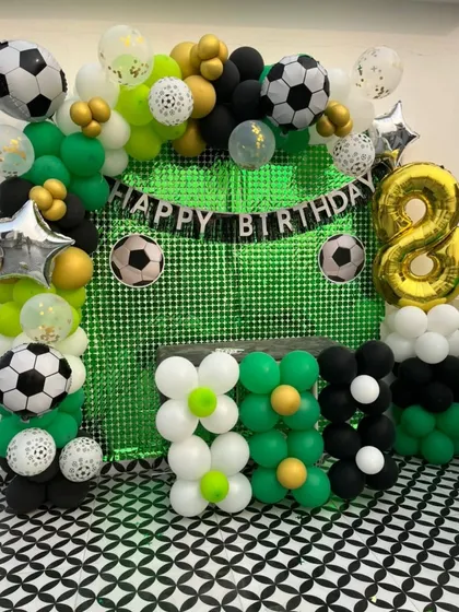 A close-up of the football theme balloon decoration, with a mix of green, black, white, and gold balloons for a dynamic look.