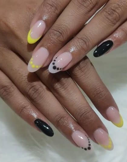 A playful design with black and yellow French tips and dotted patterns on the accent nails.