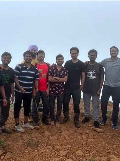 A group of trekkers on Netravati Peak, surrounded by fog.