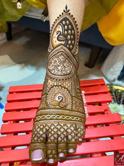 An elegant and traditional foot design with a large peacock as the main attraction, complemented by fine lines and checker patterns.