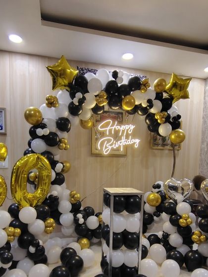 A slightly different angle of the 60th birthday decor, showing the heart-shaped foil balloons and mirrored plinth that add to the festive look.