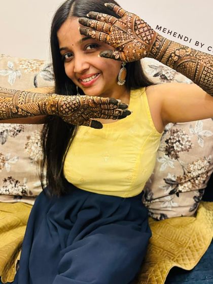 The joy on a client's face says it all. Here she is, happily displaying her full engagement mehendi, ready for her special day.