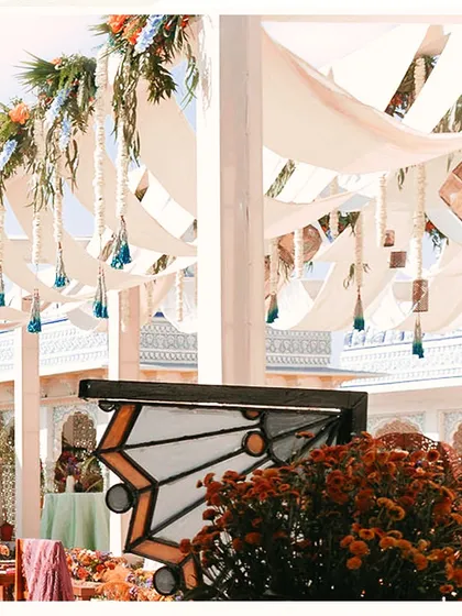 A close-up of the ceiling decor, featuring flowing drapes and hanging tassels. This adds texture and movement to the space, creating a dynamic and festive atmosphere.