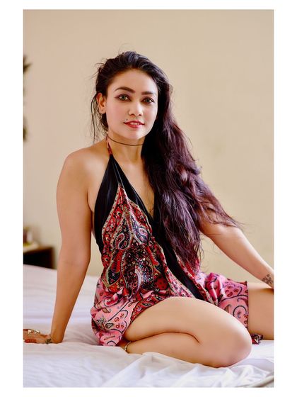 A playful and relaxed indoor portrait. The model's happy expression and casual pose create a warm and inviting image.