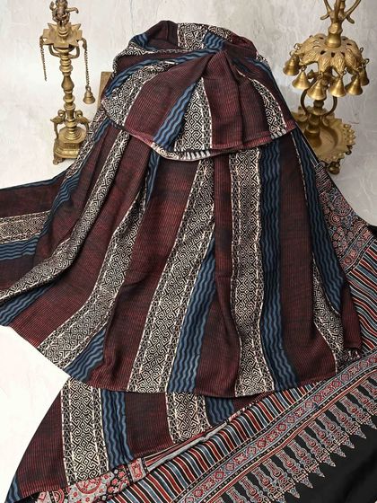 A beautiful striped and block-printed saree in earthy tones of maroon and blue. The texture and pattern make it a unique and artistic piece for everyday wear.