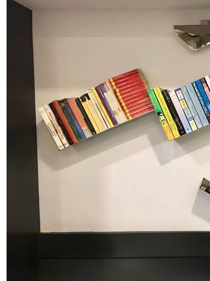 A throwback to a stainless steel bookshelf I designed many years ago. It creates the illusion of books floating on the wall.