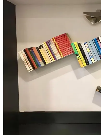 A throwback to a stainless steel bookshelf I designed many years ago. It creates the illusion of books floating on the wall.