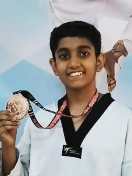 A young boy smiles with his bronze medal. Every medal, regardless of color, is a mark of courage and effort.