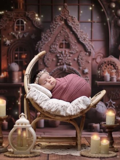 A cozy and magical Christmas gingerbread house theme. The warm lighting from the candles and fairy lights creates an enchanting atmosphere for this festive newborn shoot.