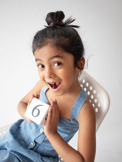A bright and expressive shot for a sixth birthday celebration. Her happy expression shows the fun and excitement of turning six.