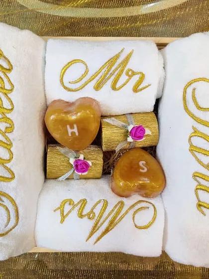 The perfect couple hamper does exist. This set includes bath towels with the couple's names, hand towels for the 'Mr' and 'Mrs', and heart-shaped soaps with their initials, all beautifully arranged.