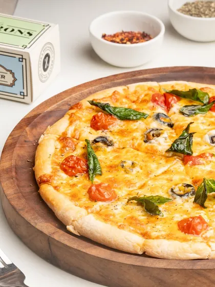 My Margherita pizza is a testament to classic simplicity. It's made with a rich tomato sauce, fresh mozzarella, cherry tomatoes, and basil.
