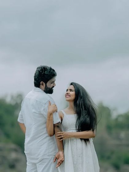 A romantic portrait of a couple against a natural, hilly backdrop. The simplicity of the scene allows their connection to be the main focus.