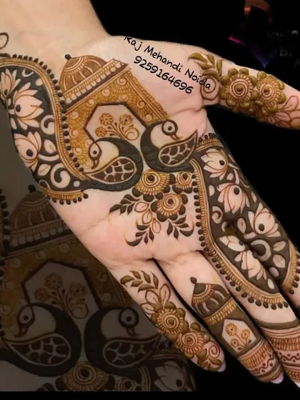 A striking design featuring peacocks and architectural jharokhas. The bold, dark application of henna makes this pattern truly stand out.
