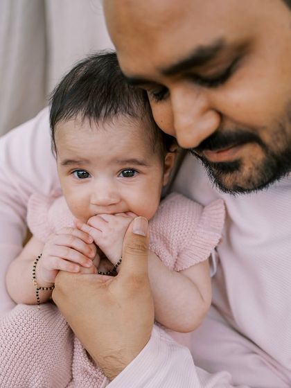 A father holding his three-month-old daughter. It's amazing to see how much they change in just a few months.