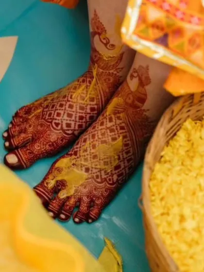 Wow, look at that stain! The deep red color on the feet, adorned with peacock motifs, looks absolutely stunning during this haldi ceremony.