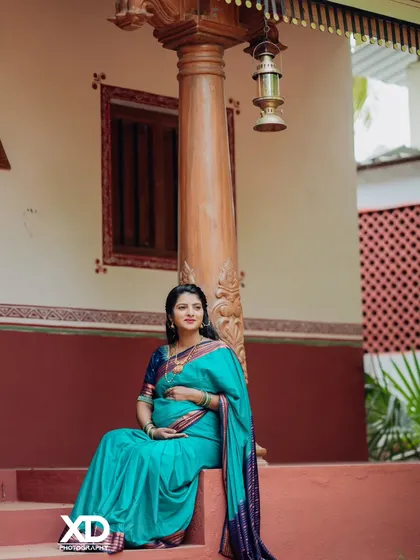 A peaceful solo portrait of the mother-to-be seated on a swing, cradling her baby bump.