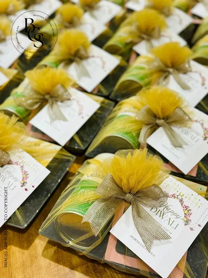 A beautiful arrangement of small festive gifts. Each item is wrapped with a yellow tulle bow and a custom "Happy Diwali" card, making them perfect as return favors or add-ons to a larger hamper.