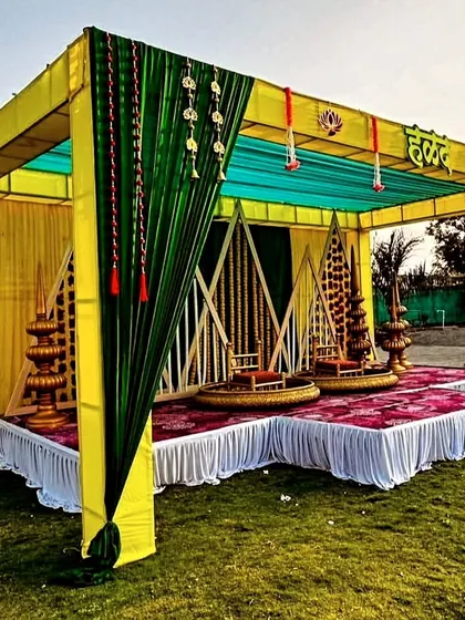 Another angle of the grand outdoor Haldi stage, showcasing the canopy structure and the spacious lawn setting.