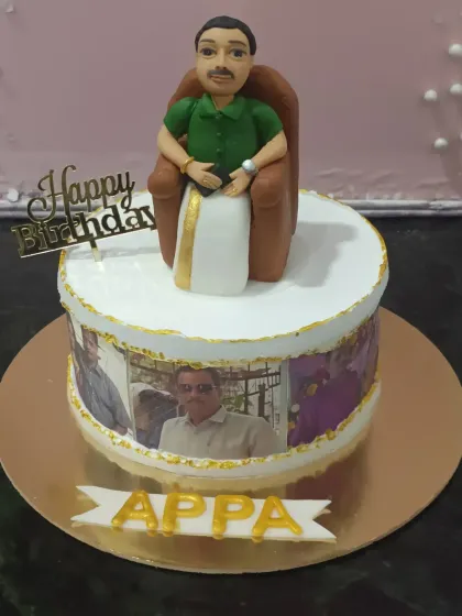 A tribute to "Appa" on his birthday. This cake features a custom fondant figurine of him relaxing in his chair, with an edible photo strip of family pictures wrapped around the base.