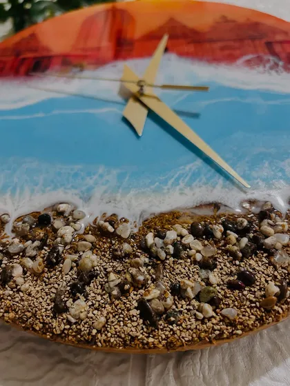 A close-up of the real sand and pebbles on the Jagannath Puri clock, creating a textured shoreline where the resin waves meet the land.