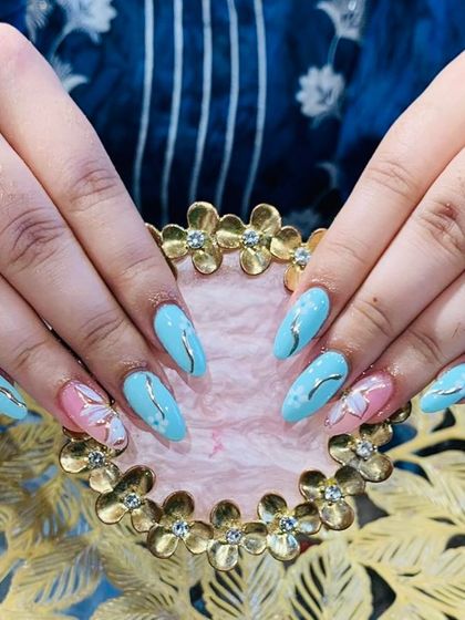 A lovely pastel blue set with silver wave details and accent nails featuring a butterfly design.