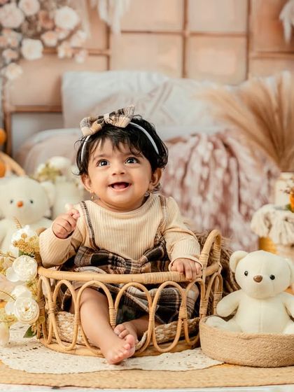 A basket of cuteness. This little girl is surrounded by her teddy bear friends in a warm, boho-inspired setup.