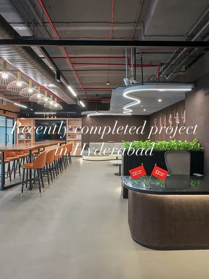 A recently completed project in Hyderabad, this reception area features a curved desk, warm wood tones, and integrated planters. The space flows directly into a large cafe and collaboration zone.