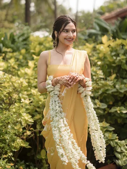 The bride holding her beautiful white floral kaleeras, a modern twist on the traditional accessory.