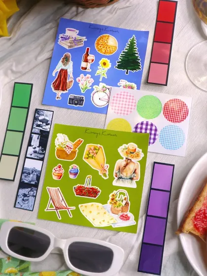 The peel-off sticker sheets from the Picnic-themed kit, featuring cute illustrations of picnic baskets, food, and people enjoying the outdoors.