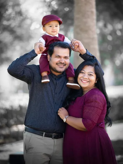A classic family pose with the little one on dad's shoulders. This black and white photo with a pop of color is a fun, artistic choice.