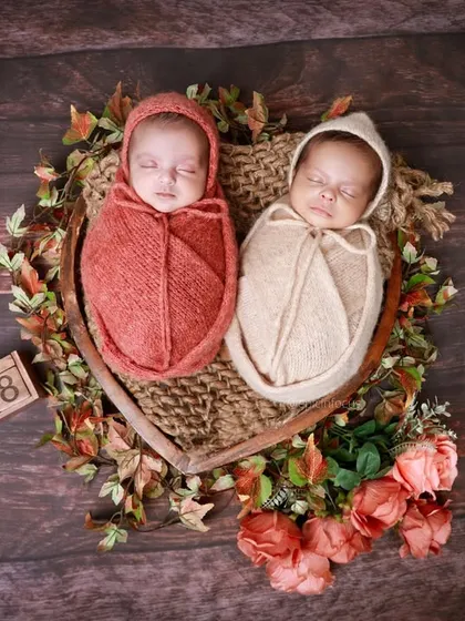 A heartwarming portrait of newborn twins nestled together in a heart-shaped basket. We have extensive experience with twin photoshoots, ensuring both babies are posed safely and beautifully.