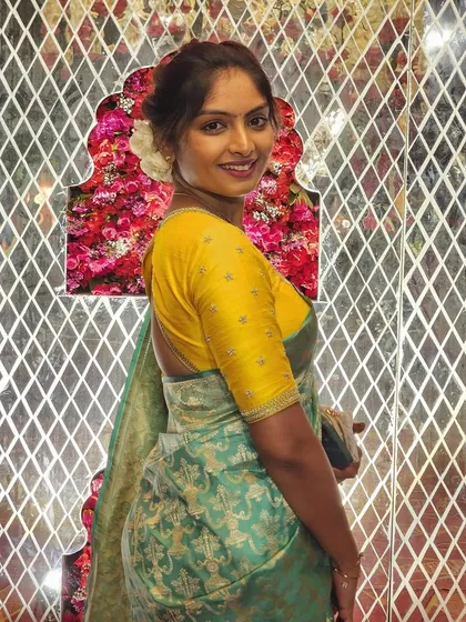 A smiling portrait of the client in her yellow and green ensemble, perfect for a daytime event.