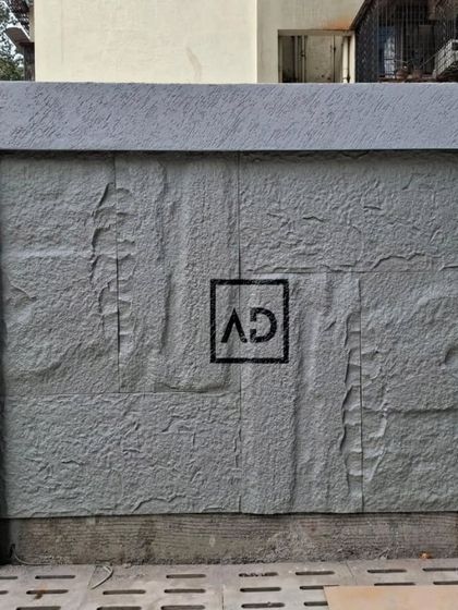 A finished exterior wall section featuring grey PU stone cladding. This is a great way to add texture and a modern, rugged look to compound walls or building exteriors.