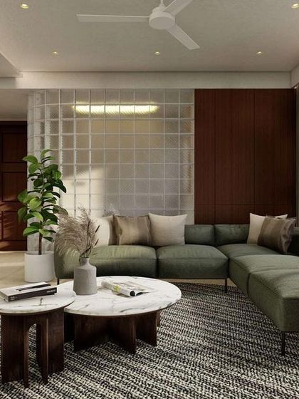 A rendering of a cozy family lounge, featuring a comfortable green L-shaped sofa set against a backdrop of a glass block wall and rich walnut wood paneling.