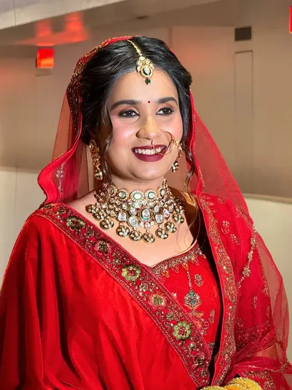 A moment of pure bridal bliss. This bride's joyful expression is perfectly complemented by her heavy kundan choker and maang tikka, creating a timeless and heartwarming wedding portrait.