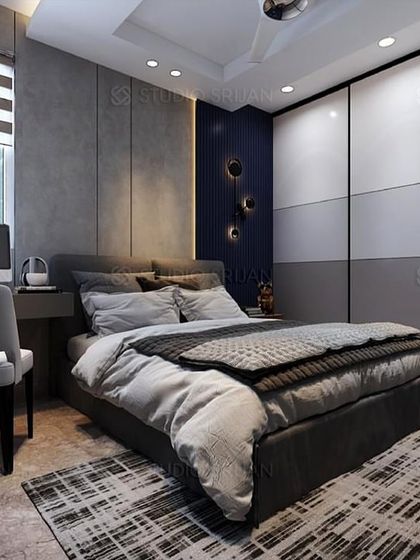 This bedroom combines cool grey tones with a deep blue accent wall. A compact desk next to the bed makes it a perfect setup for a teenager's room or a guest room with a workspace.