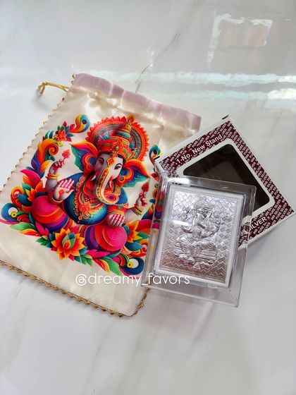 Another option for a Ganpati favor, this set includes a silver-plated Ganpati frame. It comes packaged with a beautiful cream-colored satin potli bag for a simple and elegant presentation.