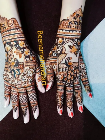 A pair of hands with two different but complementary peacock designs.
