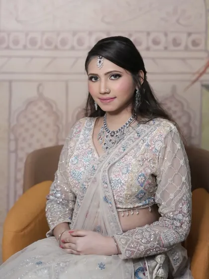 A seated portrait of the client, giving a better look at the beautiful multi-color embroidery on the blouse.