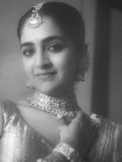 A grainy, black and white close-up that feels like a still from a classic film. The bride's gentle smile and the soft focus create a portrait that is both nostalgic and timeless.