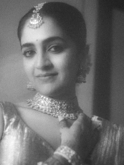 A grainy, black and white close-up that feels like a still from a classic film. The bride's gentle smile and the soft focus create a portrait that is both nostalgic and timeless.