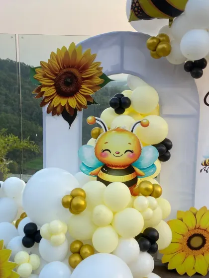 We love adding playful details, like this adorable cartoon bee, to our balloon arrangements. It adds a touch of whimsy to the sophisticated bee-themed baby shower decor.