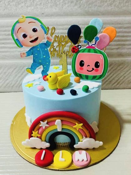 A sweet and simple Cocomelon cake for a first birthday. This design features JJ, a colorful rainbow, and a cute yellow duck, perfect for a little one's celebration.