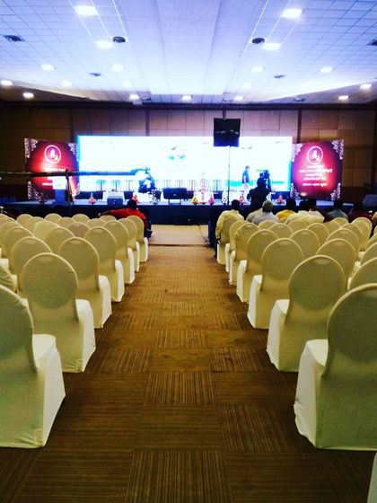 Another perspective of a large conference hall, highlighting the scale and precision involved in setting up for major corporate events. The wide stage and large LED screens are essential for audience engagement.