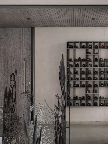 The metalwork of the railing is juxtaposed with other design elements in the home, like a custom shelving unit and a wooden door, showing how our art integrates into a complete design vision.